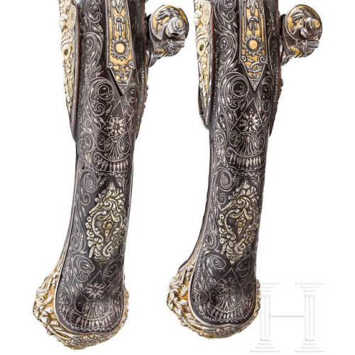 A pair of chiseled, gold and silver inlaid flintlock pistols crafted in France, circa 1810-1820.from