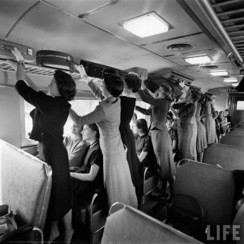 Smith College students practice the proper technique and posture for stowing luggage(Yale Joel. 1958