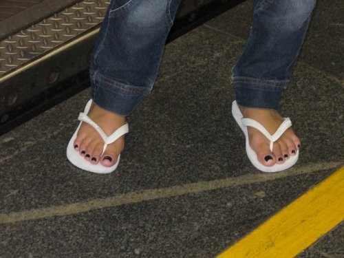 mesmerizingfeet: Tanned feet in immaculate flip-flops.