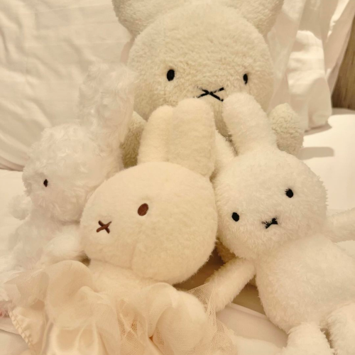 A photo of four different Miffy plushies piled together.