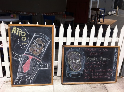 Tag team chalkboards by Kyle and Lila! Take the Tricky Dick challenge at Not a Burger Stand!