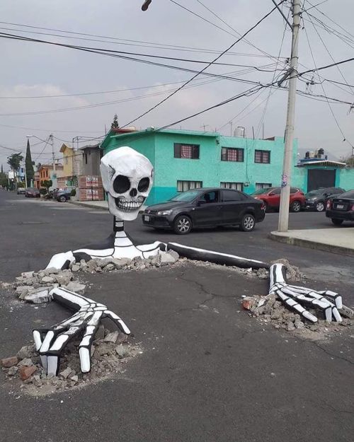 itscolossal:An Enormous Skeleton Emerges in the Middle of a Mexican Street for Día de Muertos