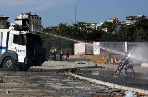 Police Enter Taksim Square in Istanbul1. Protesters take cover from a police water cannon during cla