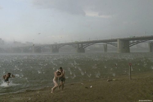 untrustyou:Russian beachgoers get caught in a rare summer hailstorm. Novosibirsk, Russia 14th July 2