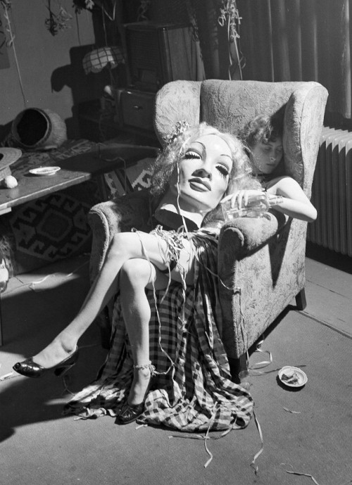 Young artist falls asleep with papier maché mask of Marlene Dietrich on her lap, 1950.  