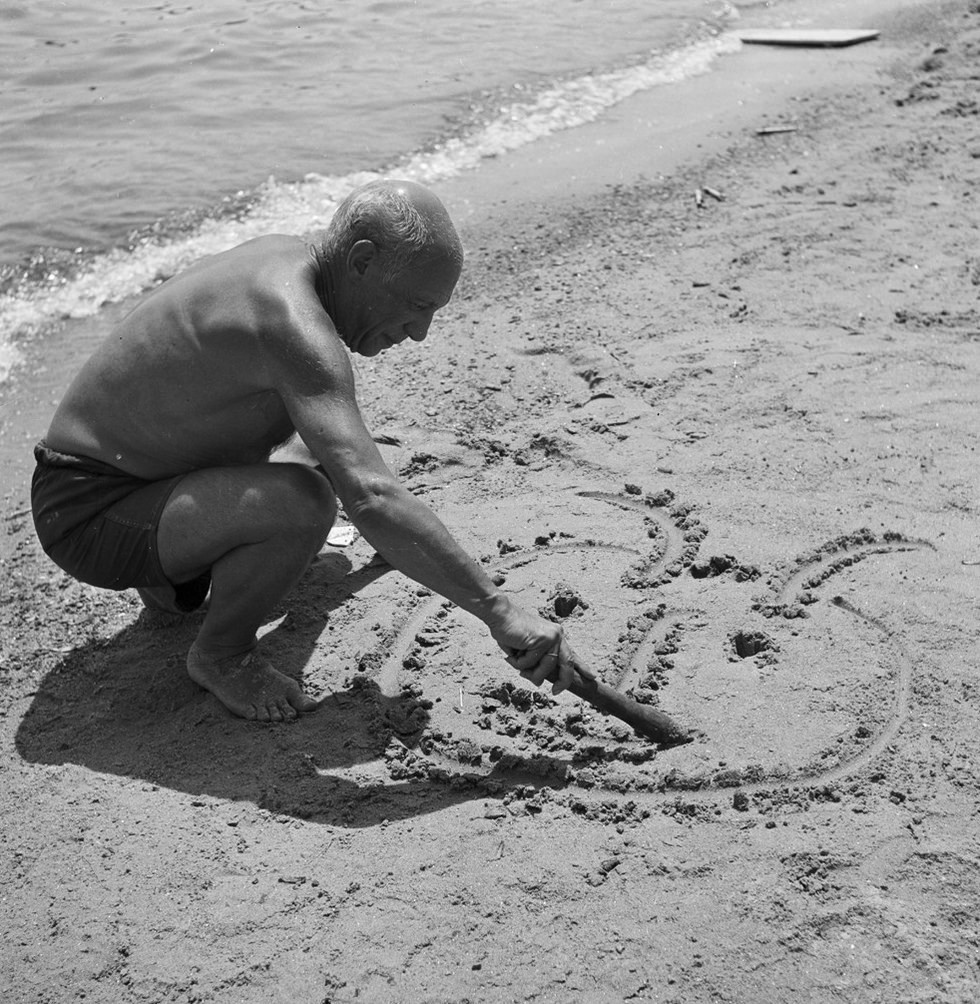 kitty-n-classe:Pablo Picasso dessinant sur le sable, par Willy Rizzo (Juan-les-Pins,