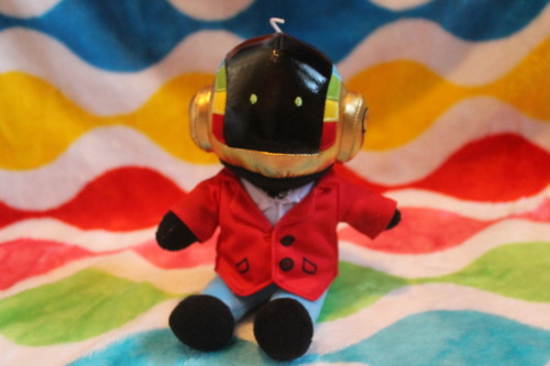 GM08 sitting by himself against the rainbow blanket backdrop.