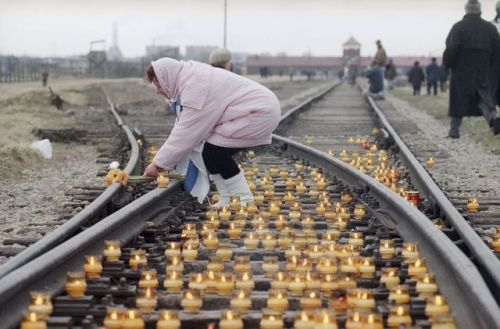 soldiers-of-war: POLAND. January 27, 1995. A woman lights a candle on the rail tracks leading to the