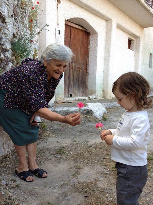 Greek grandmother offering her grand daughter a flower in the Village of Kastania,Messinia in Pelopo