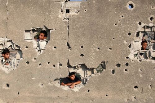 xne:Palestinian children look out from their family’s house,...