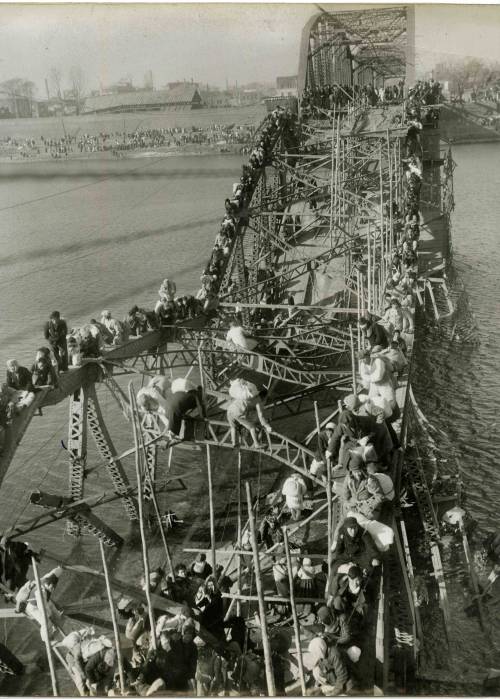 historicaltimes: Residents of Pyongyang crawl perilously over shattered girders of the city’s 