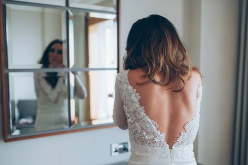 The bride wears a backless wedding dress for a Vintage Glam Inspired City Wedding. Captured by Remai