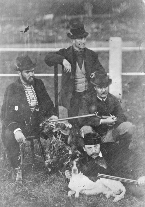 Tintype portrait of a group of armed hunters posing with their catch of game birds and a dog, c. 188