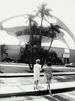 midcenturymodernfreak:1964 With his trademark tilted horizon, Garry Winogrand’s photograph of two women in front of the Theme Building by architects William Pereira, Paul R. Williams, Charles Luckman, &amp; Welton Becket | Los Angeles International