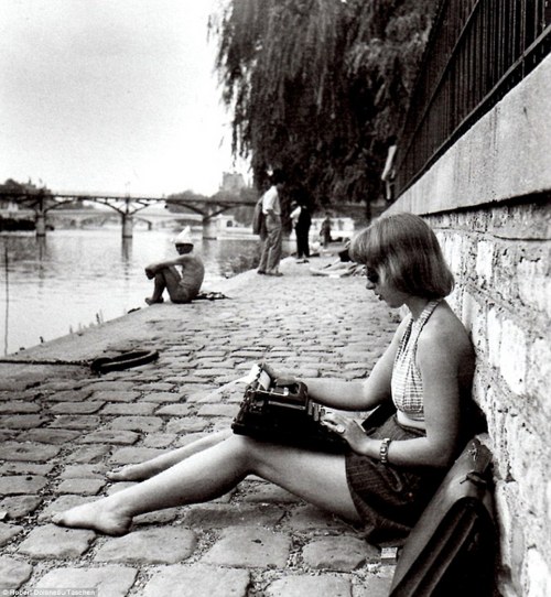 frenchvintagegallery:    Working girl   enjoying the sunshine with a typewriter balanced on her knees near the Seine, Paris, 1947 by Robert Doisneau 