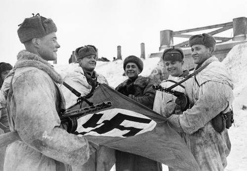 Soviet intelligence agents pose with a captured Nazi flag on the eastern front, 1942. [x]
