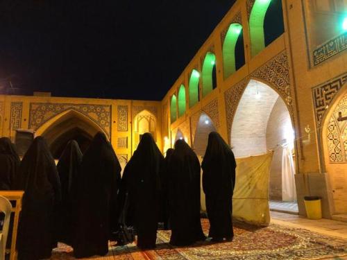 Women and men pray next to each other, with a partition, in the courtyard of Isfahan’s Jameh Mosque 