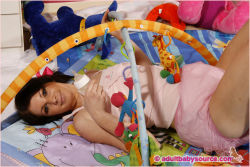 plasticpantslove:    The adult baby is playing in a pink, frilly plastic pants and a nappy.   