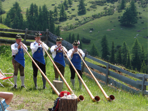 Men playing Alphorns or Alpenhorns (or Alpine horns), a tradition that dates back to the 16th centur