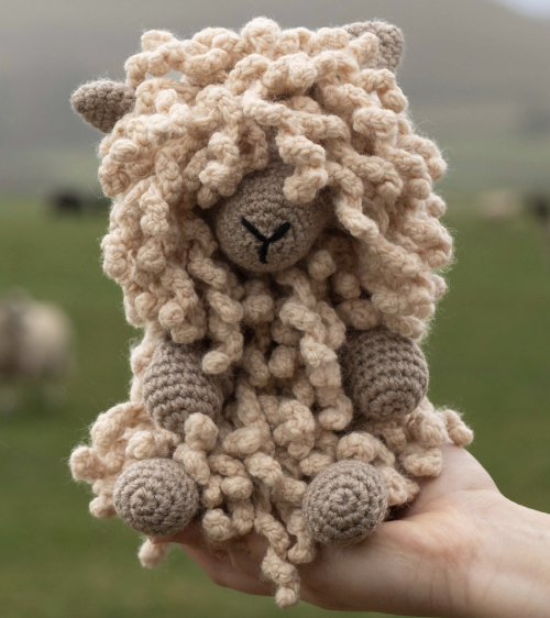 promo pic from TOFT - amigurumi of a wooly sheep placed on someone's hand