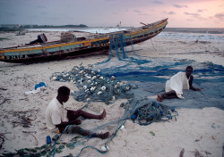 unrar:    Gabon, Cap Lopez, near Port Gentil 1984. Fishermen repairing their nets, Bruno Barbey. 