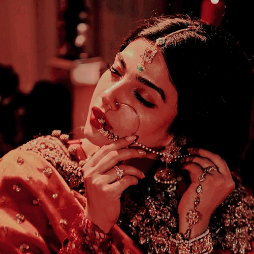 the same bride as image 1. her eyes are closed and she is touching her bejewelled nose ring. 