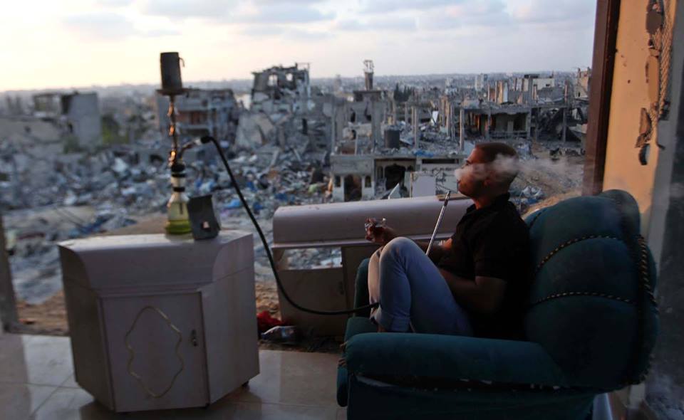 monabbasheer:  A Palestinian man smoke water pipe in destroyed houses after returning