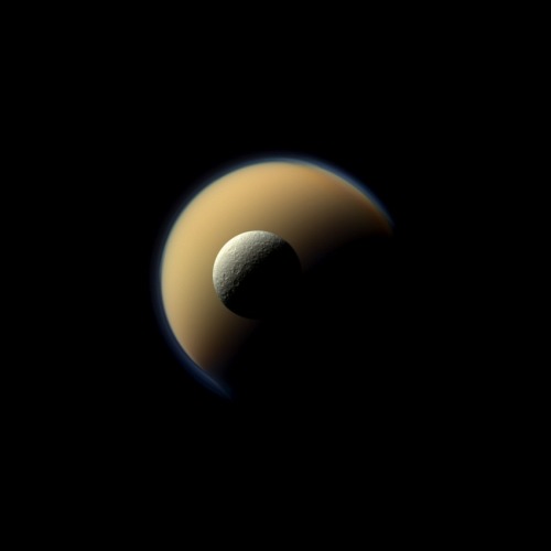 spaceexp:  Fire and Ice: Saturn’s largest and second largest moons, Titan and Rhea, juxtaposed in this true-colour image taken by the Cassini spacecraft.