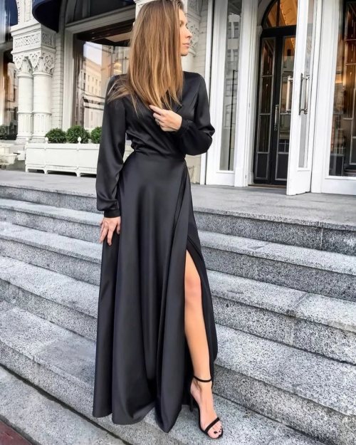 Elegant black long gown with long sleeves. Skirt shows a wrap-over giving a split and fitted waist.