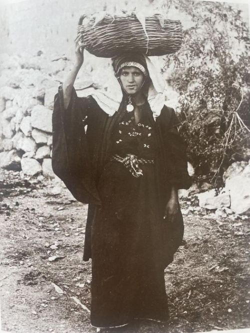 Palestinian woman carrying vegetables to