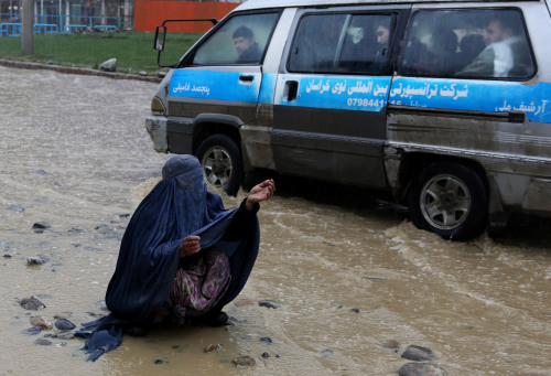 yahoonewsphotos:  Photos of the day - March 16, 2014 Indian women apply colored powder on each other as they celebrate the Holi festival in Bardwan, an Afghan woman begs on a flooded street in the city of Kabul and the equestrian team competition CSIU25