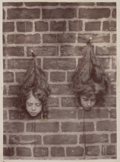 Heads of young children suspended on brick wall (by State Library of Victoria Collections) An artist