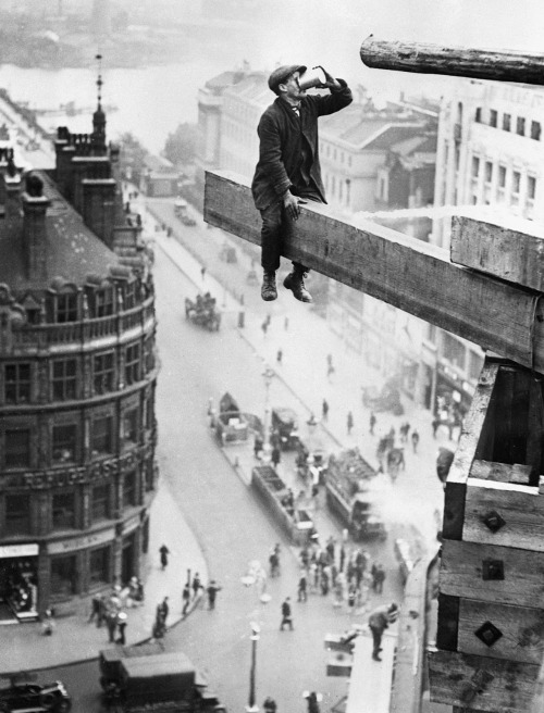 vintageeveryday:Workman drinks tea on a plank high above the Strand, London, c.1915.