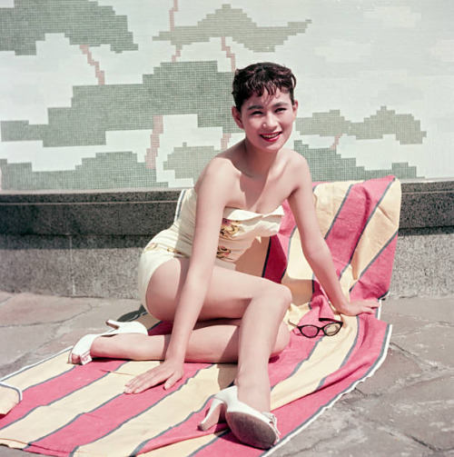 s-h-o-w-a: Japanese actress Mie Kitahara posing in a swimsuit sitting on a beach towel, Japan, late 