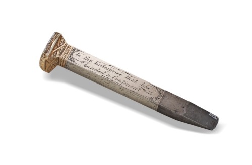 A STEEL RAILROAD SPIKE CLAD IN GOLD AND SILVER USED IN THE CEREMONY MARKING THE COMPLETION OF THE TRANSCONTINENTAL