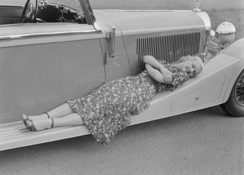 “Woman laying down on the running board of a Mercedes-Benz car, taken by Zoltan Glass, c. 1933