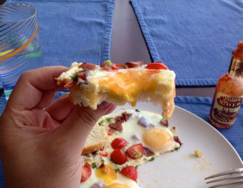 Breakfast bite: eggs on bread with smoked sausage, scallion, cherry tomato, and a hot red Thai chili