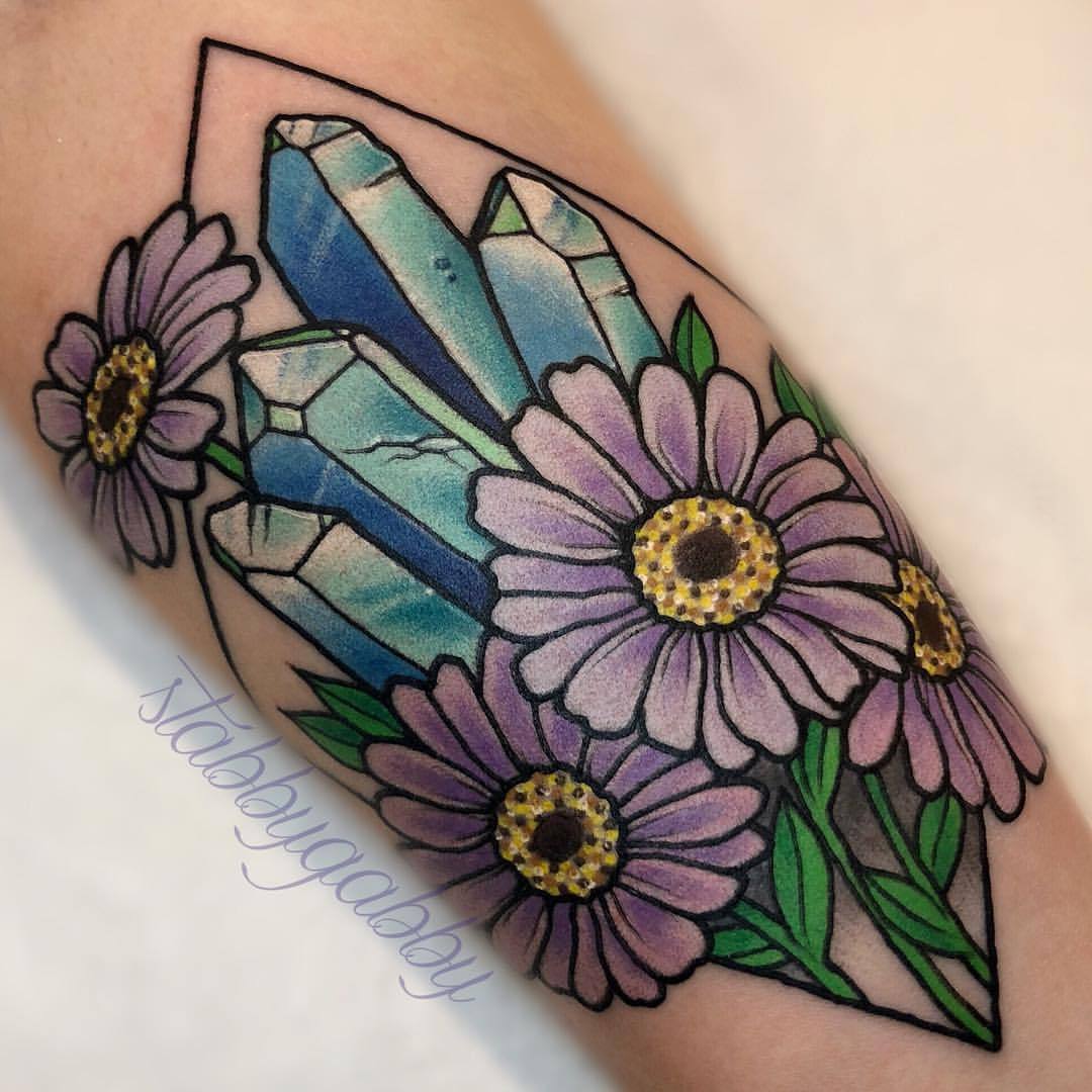 Blue dahlia flower tattooed on the inner arm,