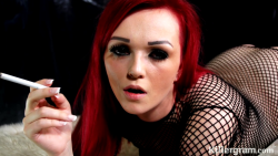 jasminejamesporn:  Redhead pornstar Jasmine James smoking  a cigarette while wearing a black fishnet bodysuit in a pic from popular British porn studio Killergram.