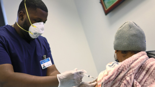 Kurtis Smith gives the Moderna coronavirus vaccine to a resident at Red Hook Neighborhood Senior Center in Brooklyn, N.Y., on Monday.