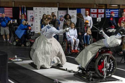 [ID: a wheelchair epee fencer attacking as her opponent leans back.]Fencing at Montreal 2018!