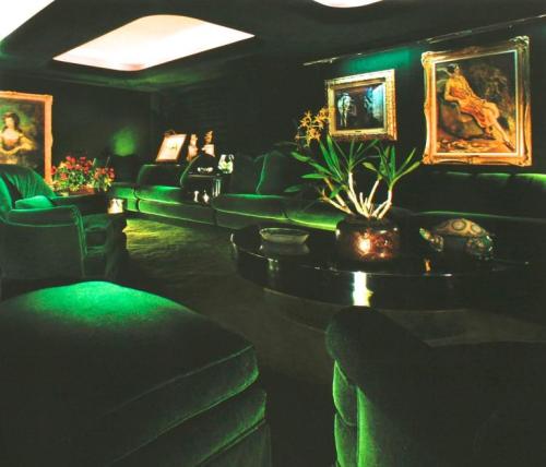 80sdeco:Iridescent emerald green walls, couch, carpet with classical gold framed paintings. From the