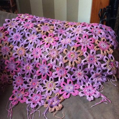 Violet crochet blanket over the arm of the sofa. #grannysquare #crochetart #crochetblanket #amandape