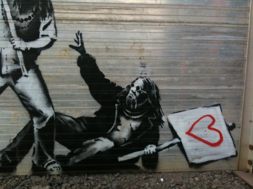 optates:  Banksy, a street artist whose identity remains unknown, known for his provocative stenciled pieces in the late 1990s.  