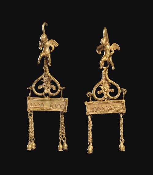 Hellenistic period Greek gold earrings depicting Eros and featuring openwork designs and pomegranate