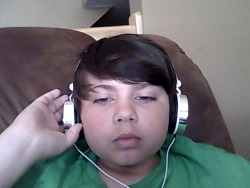 My younger brother with his headsets on(THEY LOOK SO GAY) THEY SUCK BUT HE IS GETTING BEATS SOON.THATS WHEN HE WILL LOOk BETTER(HE WANTS TO BE A DJ)HE HAS THE DDJ WE-GO SET(BLACK)