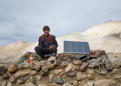  Wakhi nomad teenager sitting near a solar panel, Big pamir, Wakhan, Afghanistan.  Taken on August 1