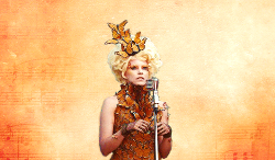 foxfacie:  The reaping takes only a minute. Effie, shining in a wig of metallic gold, lacks her usual verve. 