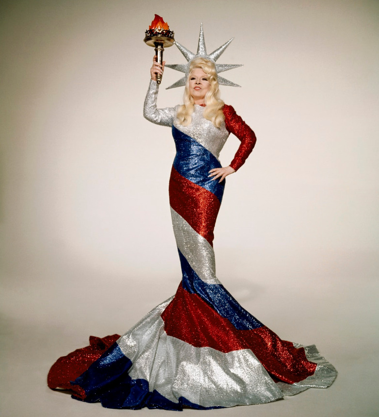 Mae West posing as a striped Statue of Liberty in a publicity still for the film Myra Breckinridge (1970).  Photo by 