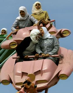 Palestinians enjoy a ride at an amusement